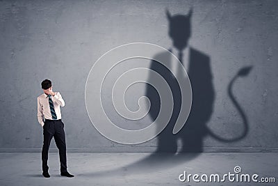 Business man looking at his own devil demon shadow concept Stock Photo
