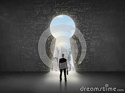 Business man looking at keyhole with bright cityscape concept Stock Photo