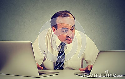 Business man multitasking working on two computers in his office Stock Photo