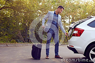 Business man opens car trunk Stock Photo