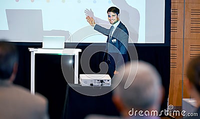 Business man, podium and presentation, point at projector screen at conference or workshop with laptop for PPT Stock Photo