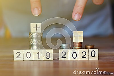 Business man pointing his fingers to stack of coins and plus sign,minus sign world economic.business concept Stock Photo