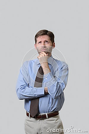 Business man with quizzical look and arms crossed Stock Photo