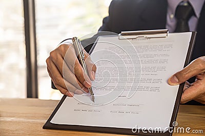 Business man signing a contract. Owns the business sign personally, director of the company, solicitor. Real estate agent holding Stock Photo