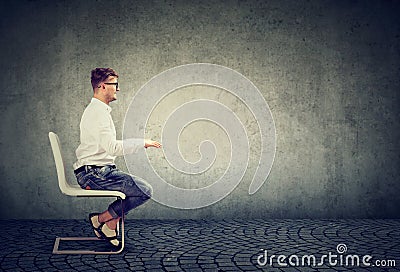 Business man sitting at invisible table pretending to type on computer Stock Photo