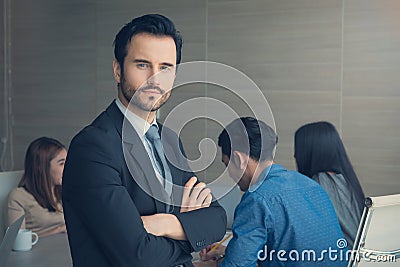 Business man smart and handsome standing with team mates working in meeting room at office Stock Photo