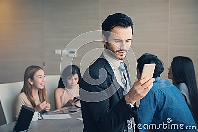 Business man smart and handsome standing using smartphone with t Stock Photo