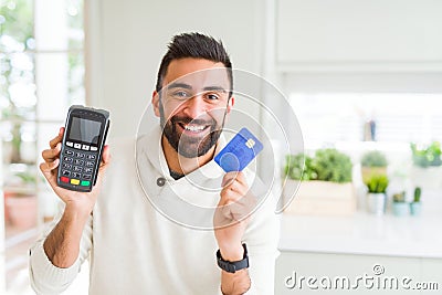 Business man smiling and holding point of sale terminal and credit card, contacless transaction Stock Photo