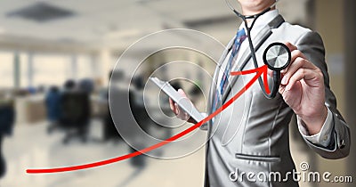 Business man with stethoscope examining red curve Stock Photo