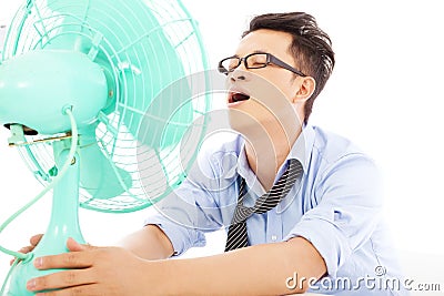 Business man suffering a hot summer heat with fans Stock Photo