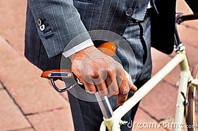 Business man in suit holding a vintage bicycle Stock Photo