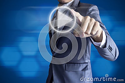 Business man touch play icon on blue background. Stock Photo