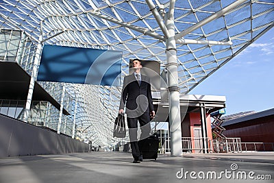 Business man travel work look the sign board walking with luggage trolley Stock Photo