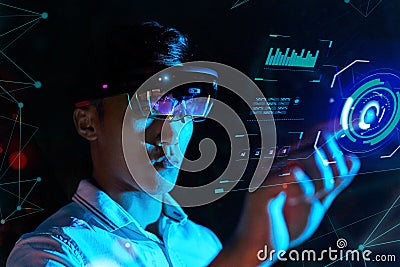 Business man try vr glasses hololens in the dark room. Young asian boy experience ar with glow earth globe on hand. Future Stock Photo