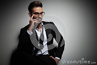 Business man in tuxedo holding hand in pocket and fixing his glasses Stock Photo