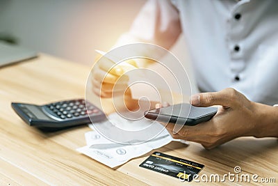 Business man using digital mobile phone scan and payment online with credit card bill on desk in home office Stock Photo