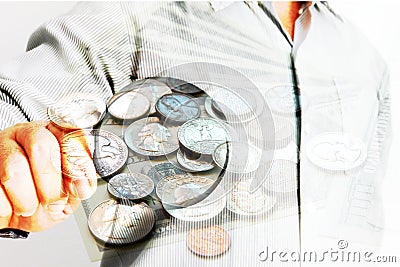 Business man using magnifying glass looking group of coins Stock Photo