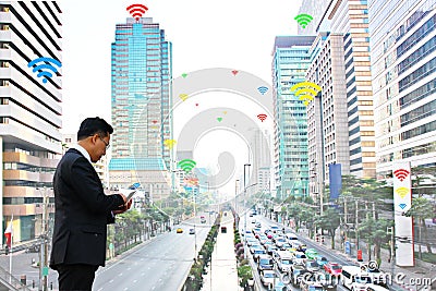 Business man using mobile phone communicate by inter net wifi which has many service providers in city Stock Photo
