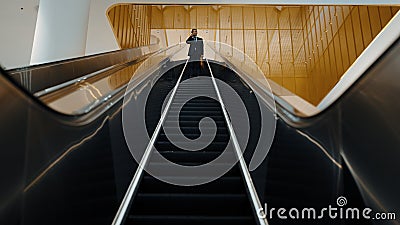 Business man using phone calling while using escalator. Front view. Exultant. Stock Photo