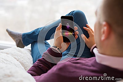 Man using virtual assistant app on mobile phone Stock Photo