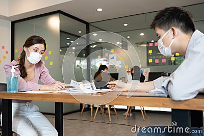 Business man and woman wearing face mask meeting and working together for discussion and brainstrom to get ideas Stock Photo