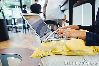 Business man working at a coffee shop with a laptop on the cozy pillow Stock Photo