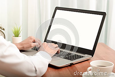 Business man working on laptop computer at home while sitting the wooden table.Male hands typing on the notebook keyboard.Online Stock Photo