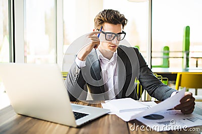 Business man working at office with laptop and documents on his desk. Analyze plans, papers, hands keyboard. Stock Photo