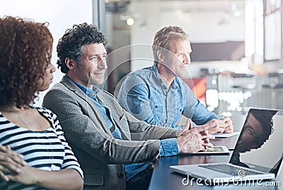 Business, meeting and listen or focus at office for entrepreneur with laptop at startup. Employees, together and Stock Photo