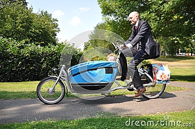 Business men riding his child to the creche Stock Photo