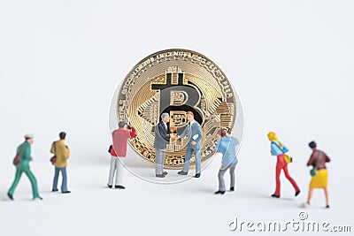 Business miniature man shaking hand accept Cryptocurrency golden Stock Photo