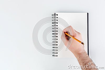 business notepad, hand holding a pencil on a white background Stock Photo
