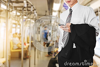 Business office employee using smartphone in subway or sky train, going to work in sunrise morning Stock Photo