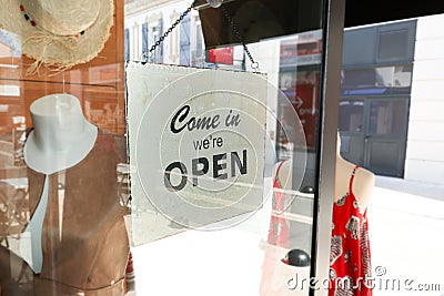 Business opening with open entrance sign in street shop through the glass Stock Photo