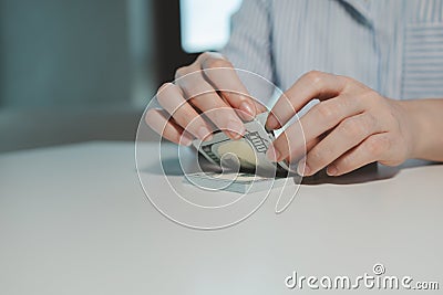 A business owner is counting money and making notes in a financial book, The financier is verifying the income received from the Stock Photo