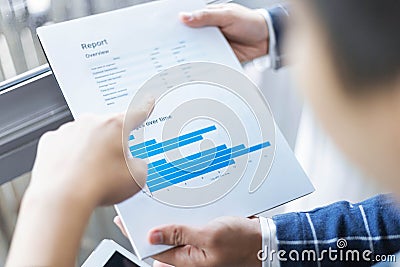 Business partners concept a young businessman revising sales summary of the recent month showing in document forms Stock Photo