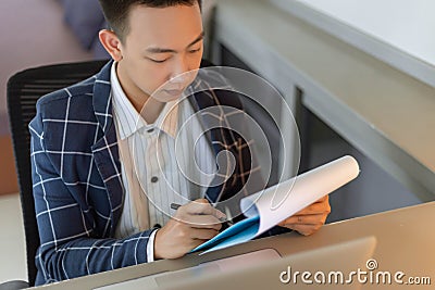 Business partners concept a young businessman revising sales summary of the recent month showing in document forms Stock Photo