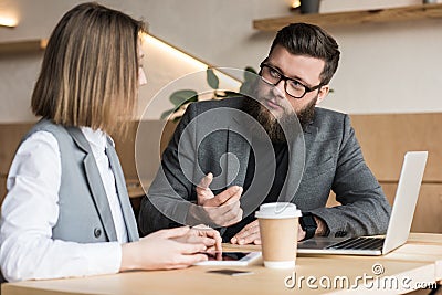 business partners having conversation in modern cafe with devices and coffee Stock Photo