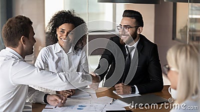 Business partners shaking hands, making agreement at group negotiations Stock Photo