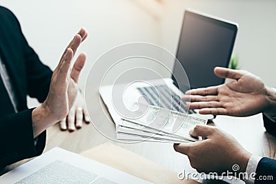 Business partners submit fraudulent cash to entrepreneurs whose male businessmen refuse to accept bribes in the office Stock Photo