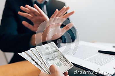 Business partners submit fraudulent cash to entrepreneurs whose male businessmen refuse to accept bribes in the office Stock Photo