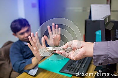 Business partners submit fraudulent cash to entrepreneurs whose male businessmen refuse to accept bribes in the office Stock Photo