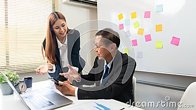 Business partnership concept, Business senior read data on smartphone while explaining to partner Stock Photo