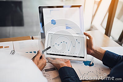 Business partnership coworkers using a tablet to chart company financial statements report and profits work progress and planning Stock Photo