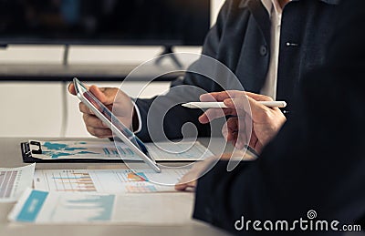 Business partnership coworkers using a tablet to chart company financial statements report and profits work progress and planning Stock Photo