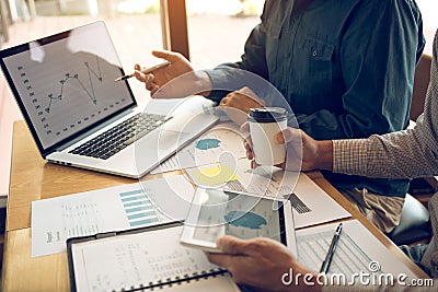Business partnership pointing to the graph of the company financial statements report and profits earned during in the computer Stock Photo