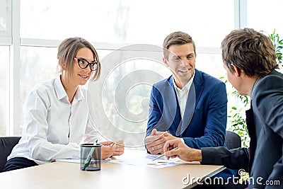 Business People Analyzing Financial Results on Graphs around the Table in Modern Office. Team Work Concept Stock Photo