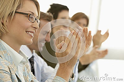 Business People Applauding At Conference Table Stock Photo