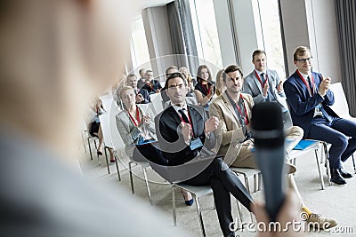 Business people applauding for public speaker during seminar at convention center Stock Photo