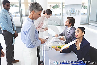 Business people checking in at conference registration table Stock Photo